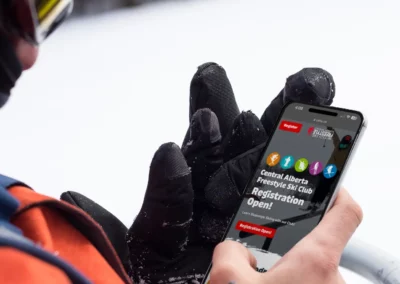 Skier looking at the central alberta freestyle ski club website on a ski lift